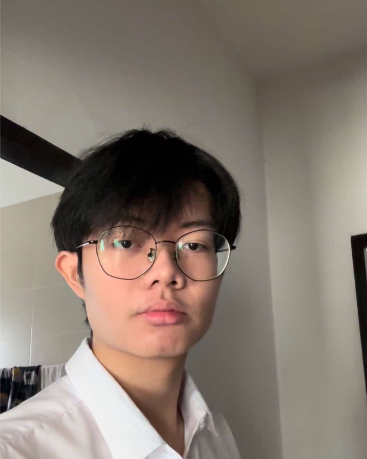 Athit Fongkhaimuk, portrait in a white shirt and round glasses